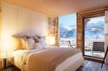 Experience luxury living in this stunning bedroom with breathtaking mountain views.