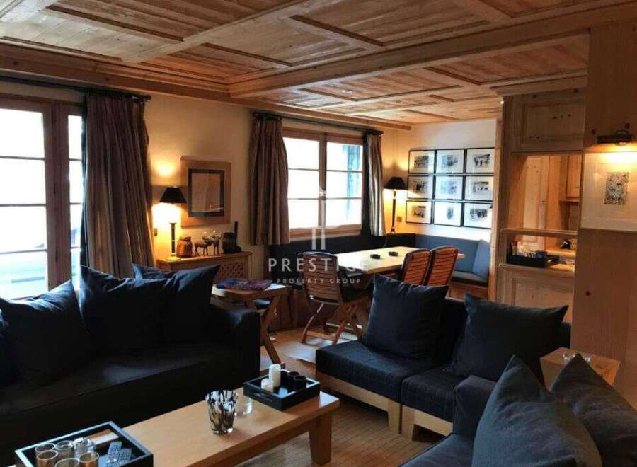 Experience the warmth of this inviting living space, featuring a stunning wooden ceiling and cozy seating areas.