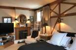 Cozy bedroom with a fireplace and a comfortable bed.