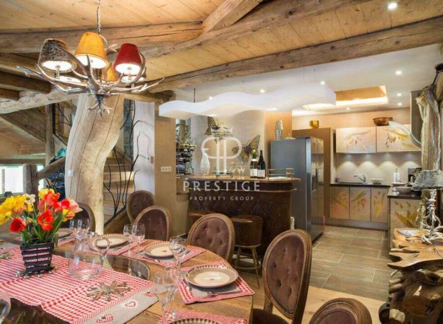 Experience luxury living in this stunning property, featuring a unique antler chandelier and rustic wooden beams.