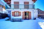 Charming chalet nestled in a snowy landscape, perfect for a winter getaway.