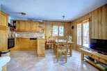 This charming property boasts a cozy kitchen with wooden cabinetry and a dining area, perfect for family meals.