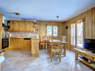 This charming property boasts a cozy kitchen with wooden cabinetry and a dining area, perfect for family meals.