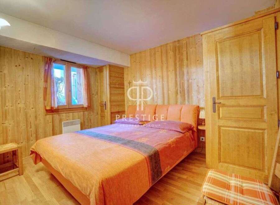 Cozy bedroom with wooden walls and a comfortable bed.