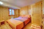 Cozy bedroom with wooden walls and a comfortable bed.