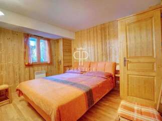 Cozy bedroom with wooden walls and a comfortable bed.