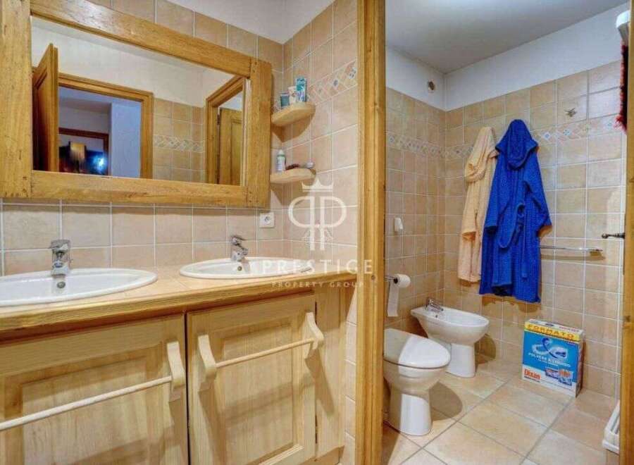 This charming bathroom features a rustic wooden vanity with dual sinks, offering ample space and a touch of natural elegance.