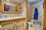 This charming bathroom features a rustic wooden vanity with dual sinks, offering ample space and a touch of natural elegance.