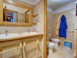 This charming bathroom features a rustic wooden vanity with dual sinks, offering ample space and a touch of natural elegance.