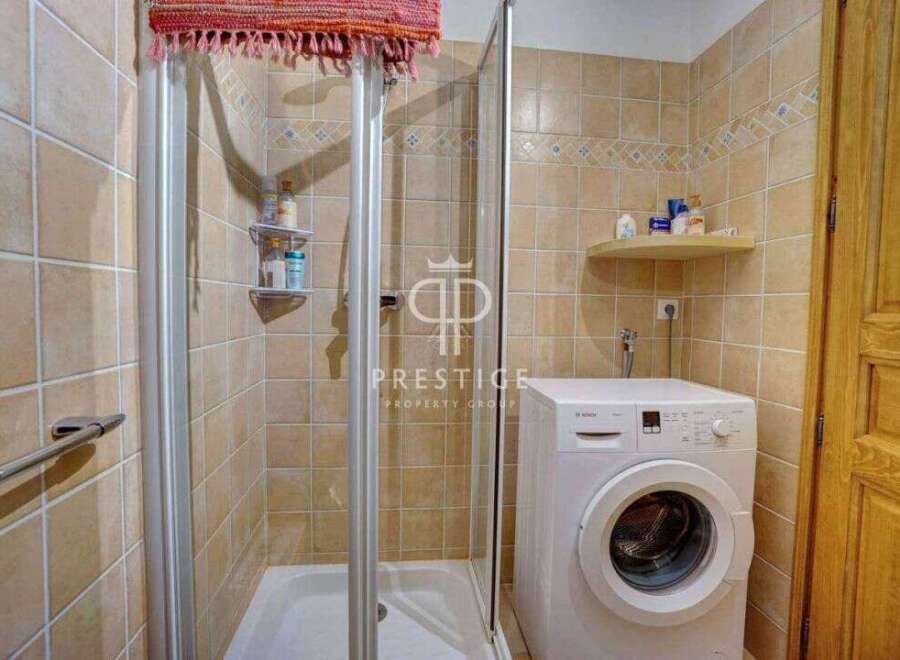 Discover a charming bathroom featuring a convenient washing machine, perfect for everyday living.