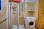 Discover a charming bathroom featuring a convenient washing machine, perfect for everyday living.