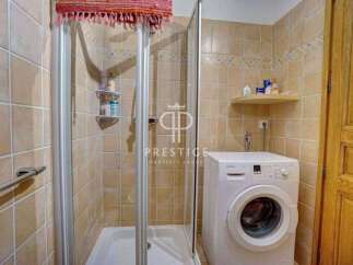 Discover a charming bathroom featuring a convenient washing machine, perfect for everyday living.