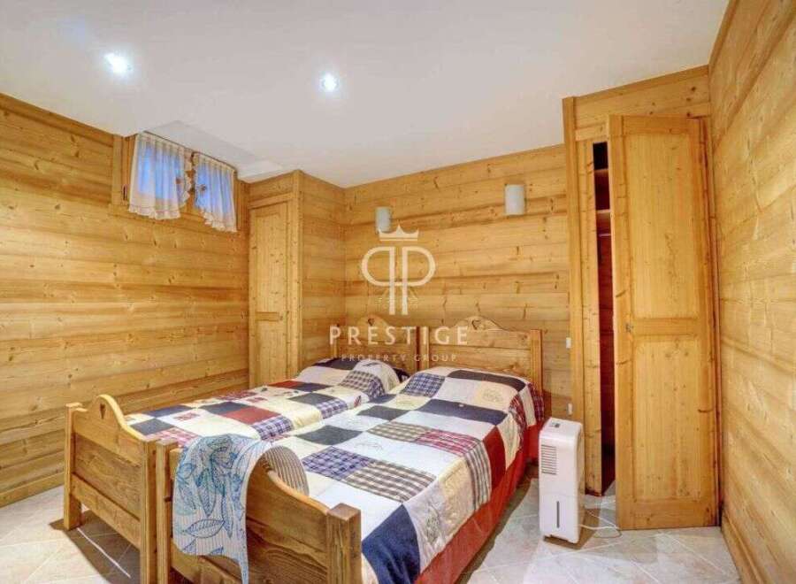 Cozy bedroom with wooden paneling, perfect for a relaxing getaway.