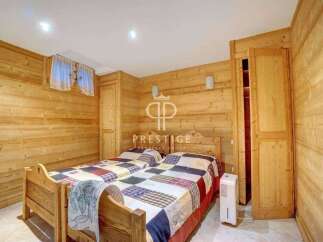 Cozy bedroom with wooden paneling, perfect for a relaxing getaway.