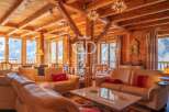 Experience luxury living in this stunning chalet, featuring a warm and inviting interior with exposed wooden beams.