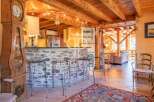 Step into rustic elegance with this stunning property, featuring a charming stone bar and a grand grandfather clock.
