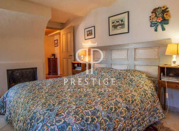 Discover the charm of this cozy bedroom, featuring a unique headboard and a fireplace for added warmth.