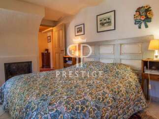 Discover the charm of this cozy bedroom, featuring a unique headboard and a fireplace for added warmth.