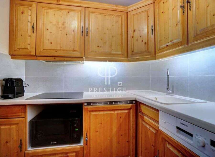 Discover this charming kitchen with its warm wooden cabinetry and modern appliances.