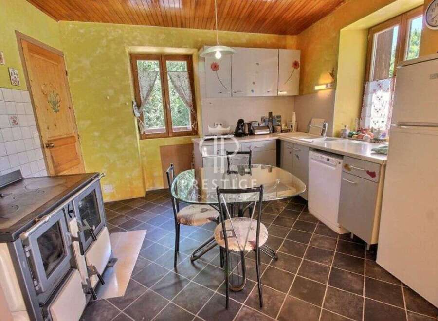 Charming kitchen with a rustic touch! This space features a classic stove, a cozy dining area, and ample natural light.