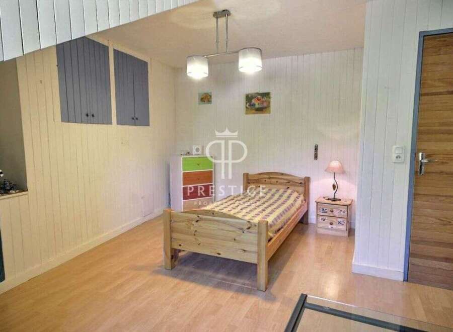 Discover a cozy bedroom with a charming wooden bed and a warm, inviting atmosphere.