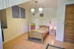 Discover a cozy bedroom with a charming wooden bed and a warm, inviting atmosphere.