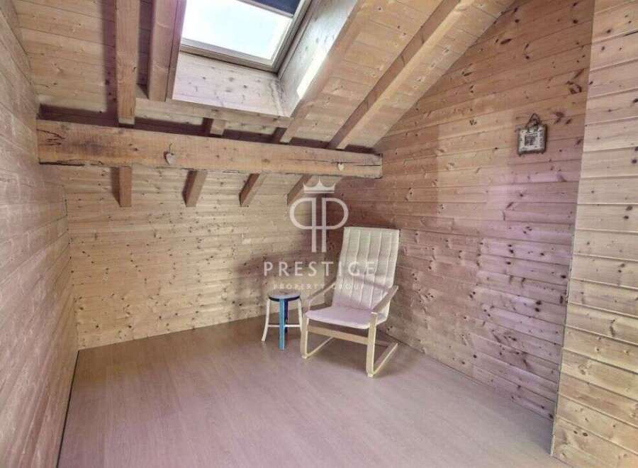 Discover the charm of this cozy attic space, featuring warm wooden paneling and a unique architectural design.