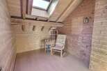 Discover the charm of this cozy attic space, featuring warm wooden paneling and a unique architectural design.