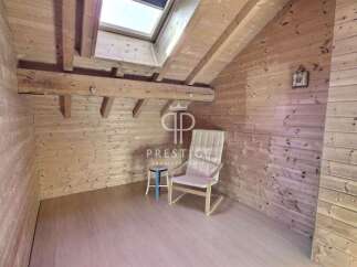 Discover the charm of this cozy attic space, featuring warm wooden paneling and a unique architectural design.