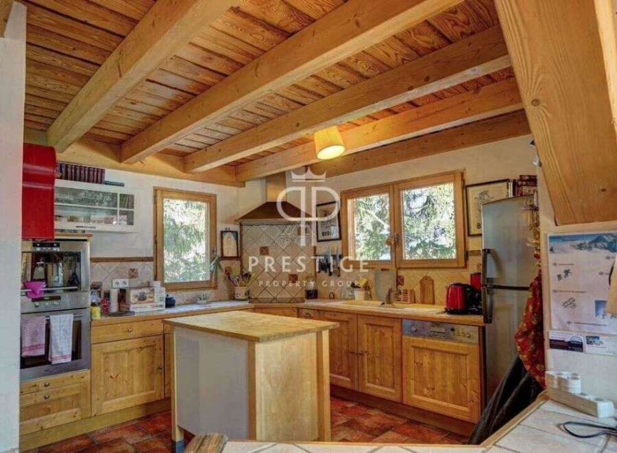 Discover the charm of this rustic kitchen, featuring warm wooden cabinetry and exposed beams that create a cozy atmosphere.