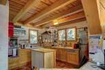 Discover the charm of this rustic kitchen, featuring warm wooden cabinetry and exposed beams that create a cozy atmosphere.
