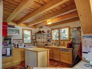 Discover the charm of this rustic kitchen, featuring warm wooden cabinetry and exposed beams that create a cozy atmosphere.