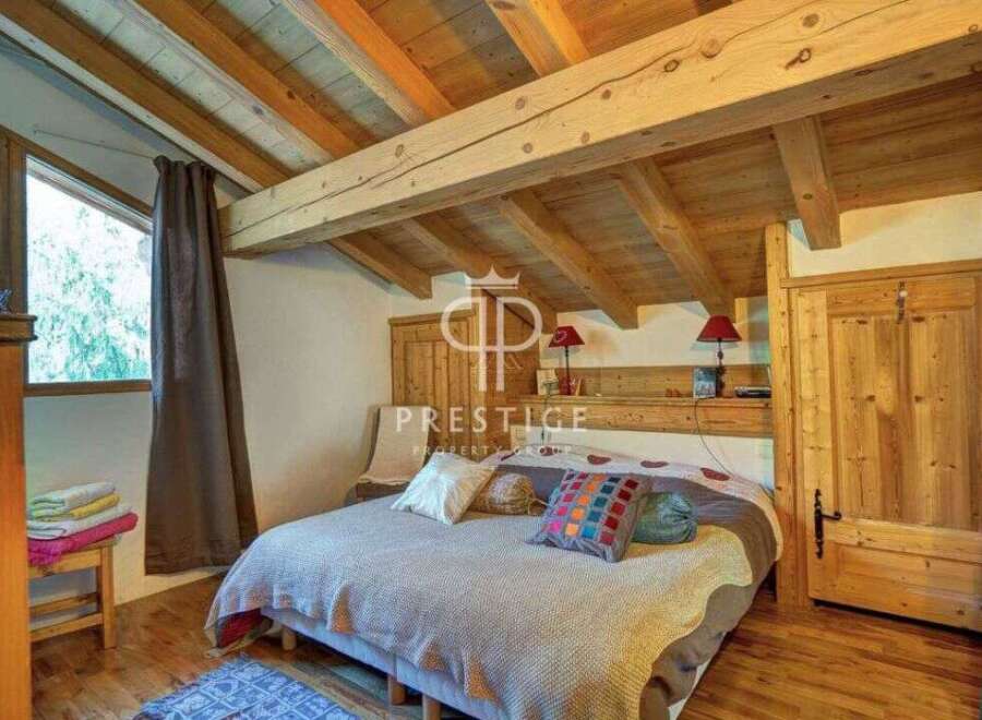 Discover the charm of this cozy bedroom, featuring a rustic wooden ceiling and beams that add warmth and character.