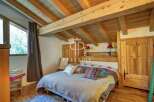 Discover the charm of this cozy bedroom, featuring a rustic wooden ceiling and beams that add warmth and character.