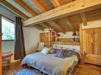 Discover the charm of this cozy bedroom, featuring a rustic wooden ceiling and beams that add warmth and character.