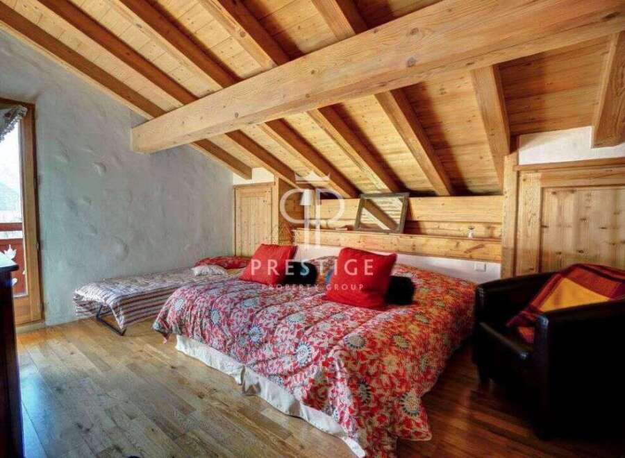 Discover the charm of this cozy bedroom with its rustic wooden ceiling and inviting ambiance.