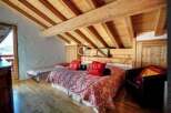 Discover the charm of this cozy bedroom with its rustic wooden ceiling and inviting ambiance.