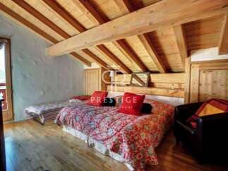 Discover the charm of this cozy bedroom with its rustic wooden ceiling and inviting ambiance.
