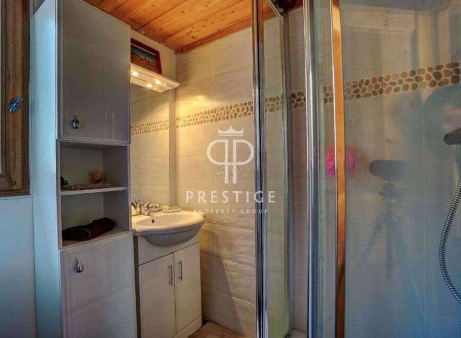 Discover this charming bathroom featuring a sleek shower enclosure and a stylish vanity.