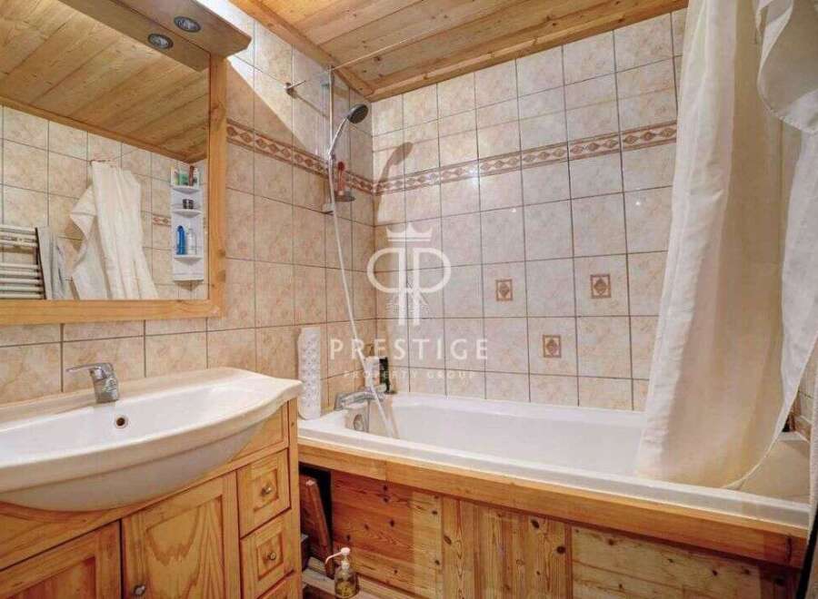 Discover a charming bathroom with a rustic wooden vanity and a pristine white sink.