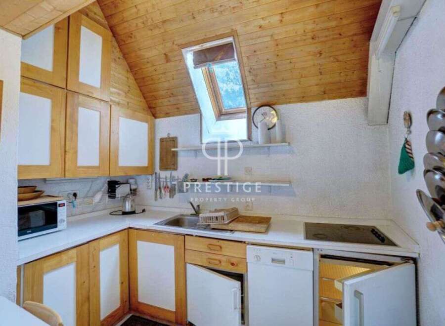 Charming kitchen with wooden cabinets and a unique skylight.