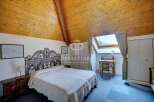 Discover the charm of this unique bedroom with its stunning wooden ceiling and cozy ambiance.