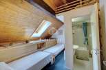 Cozy attic bedroom with two beds and a skylight, perfect for a relaxing getaway.