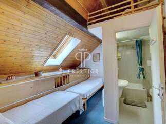 Cozy attic bedroom with two beds and a skylight, perfect for a relaxing getaway.