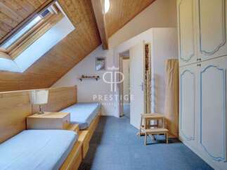 Discover this charming bedroom featuring a unique sloped ceiling and a skylight that floods the space with natural light.