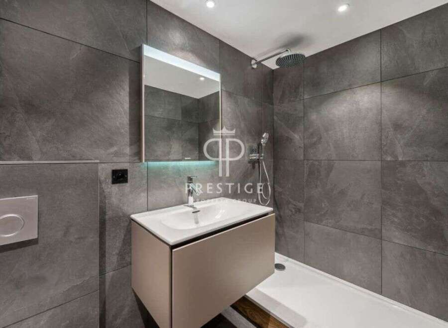 Modern bathroom design featuring sleek gray tiles and a contemporary vanity.