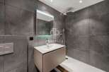 Modern bathroom design featuring sleek gray tiles and a contemporary vanity.