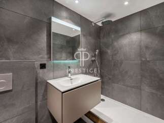 Modern bathroom design featuring sleek gray tiles and a contemporary vanity.