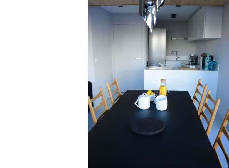 Discover a modern dining space with a sleek black table, perfect for gatherings.