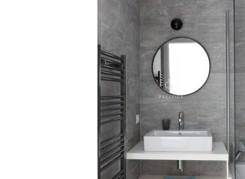 Modern bathroom design featuring a sleek, rectangular sink and a stylish round mirror.
